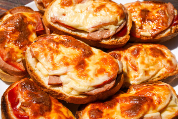 Fried sandwich in the oven, cheese and sausage on a piece of loaf