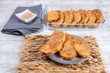 Fried bread with milk, egg, sugar and cinnamon. Typical Spanish Easter sweet. Traditional home cooking concept. Horizontal photography and selective focus
