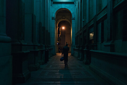 A Person Walking Down A Corridor Alone At Night