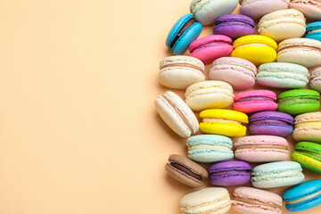 Fototapeta na wymiar Delicious colorful macarons on beige background, flat lay. Space for text