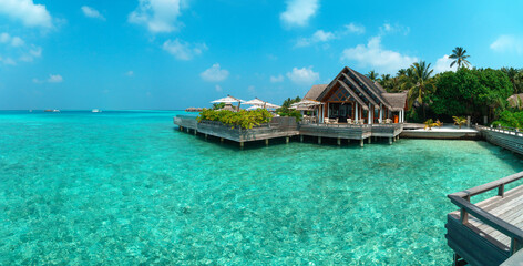 Amazing wide panorama of tropical Maldives island on a sunny day. Exotic vivid beach background...
