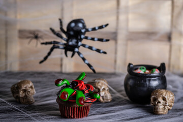 halloween cupcake, chocolate, black and red battercream and gumdrop fingers. horizontal shot and selective focus