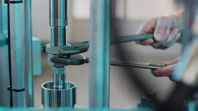 Man is screwing a nut with a wrench