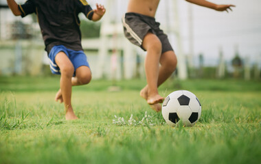 Action sport outdoors of a group of kids having fun playing soccer football for exercise in...