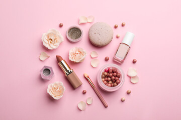 Flat lay composition with makeup products, roses and macaron on pink background