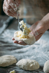 close-up view of hands making delicious pies with dough