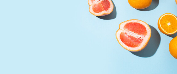 citrus fruits, oranges, grapefruit on a blue background. Top view, flat lay. Banner