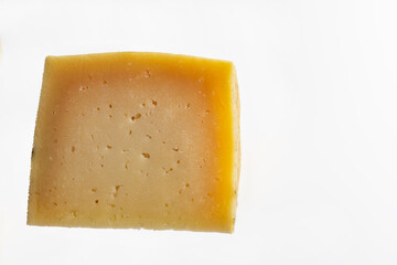 portion of cured manchego cheese on white background. Horizontal shot