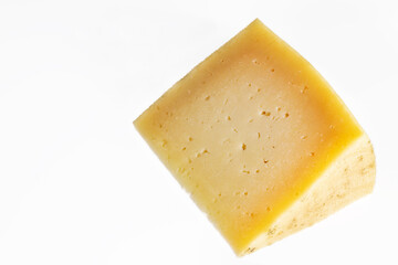 portion of cured manchego cheese on white background. Horizontal shot