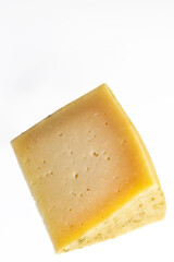 portion of cured manchego cheese on white background. Vertical shot