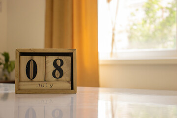 Wooden blocks of the calendar represents the date 8 and the month of July on the background of a...