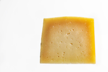 portion of cured manchego cheese on white background. Horizontal shot