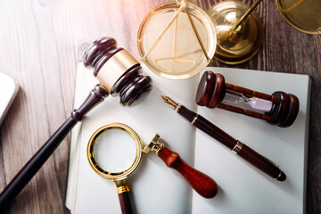 Justice and law concept.Male judge in a courtroom with the gavel, working with, computer and docking keyboard, eyeglasses, on table in morning light