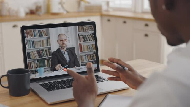 African student using laptop for video call with tutor