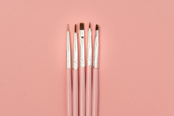 cosmetic flat lay: pink makeup brushes on pink background