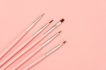 cosmetic flat lay: pink makeup brushes on pink background