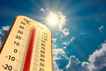 low angle view Thermometer on blue sky with sun shining in summer show higher Weather, concept...