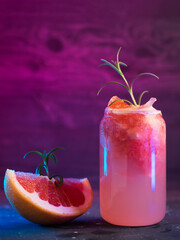 A glass of refreshing summer lemonade or alcoholic cocktail with grapefruit, crushed ice, rosemary,...