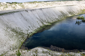 old industrial chalk quarry with water overgrown with algae and mud