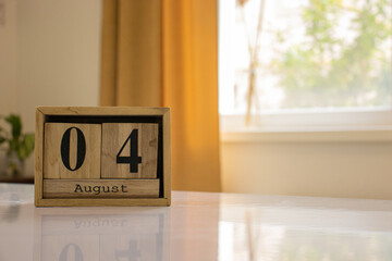 Wooden blocks of the calendar represents the date 4 and the month of August on the background of a...