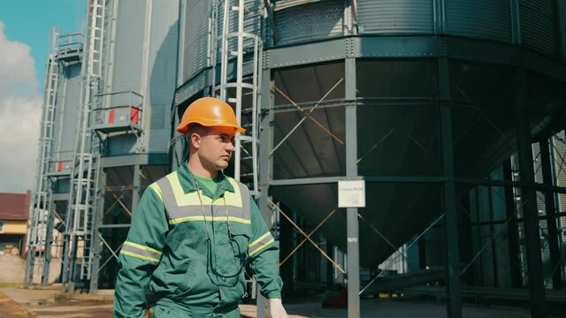 Engineer inspecting grain storage elevators. An employee of an agricultural company inspects elevator installations. Storage of grain crops