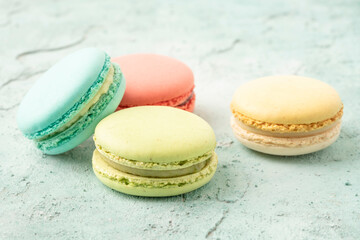 colorful macaroons on green background with copy space