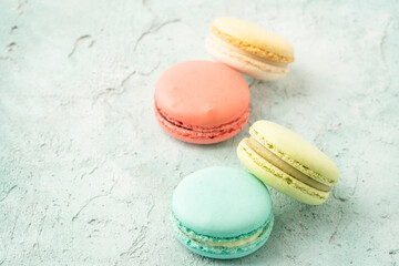 colorful macaroons on green background with copy space