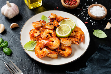 Grilled tiger shrimps with spice and lime. Black background.