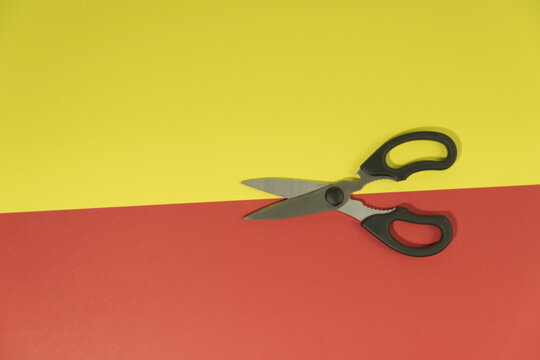 Scissors cut a red-yellow background  cardboard