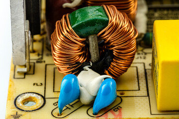 An inductor, toroidal coil on a ring with visible copper scroll, wound on a magnetic coil.