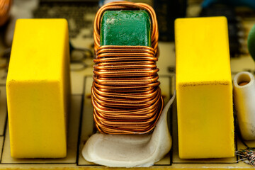 An inductor, toroidal coil on a ring with visible copper scroll, wound on a magnetic coil.