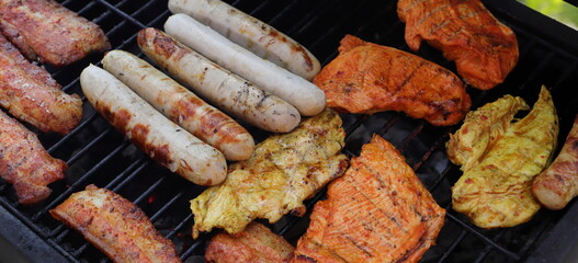 various meat and sausages on the charcoal grill