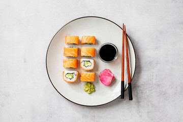 Traditional sushi - Philadelphia with salmon, cucumber avocado and cream cheese. Japanese cuisine. Top view. Light gray  background, top view