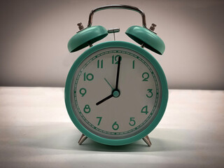 green classic style alarm clock isolated on grey white background (vintage look). 