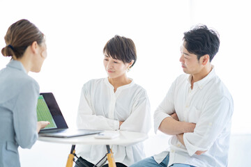 スーツ姿の女性から説明を受ける夫婦