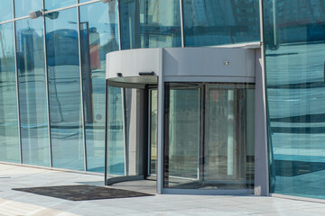 Revolving carousel rotary doors at entrance to building of shopping center, office, bank.
