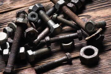 Old rusty bolts and nuts on the carpenter workbench background.