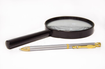magnifier and pen lies on a white background. office supplies. office items