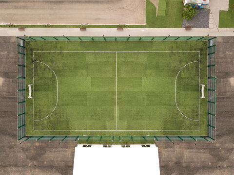 Aerial top down drone photo of green football pitch empty to be used for soccer game.