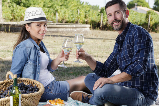 couple enjoying a bottle of wine in the vineyard - Powered by Adobe