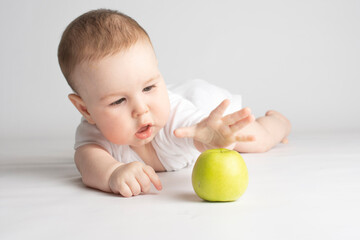 child reaches for a green apple