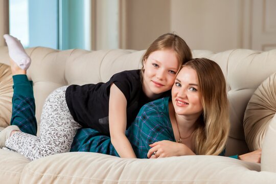 Happy mother and little her cute daughter in living room