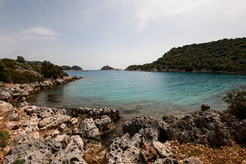 Fototapeta na wymiar View of turquoise water of the sea and rocky coast and blue sky