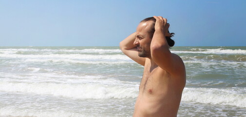 Fototapeta na wymiar Uomo in vacanza in estate al mare 