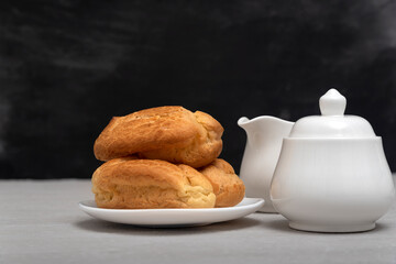 Lush homemade eclairs and tea-drinking utensils. French pastries