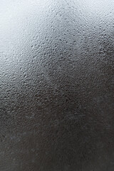 Window glass with water drops. Abstract gray background with drops and stains. Vertical frame
