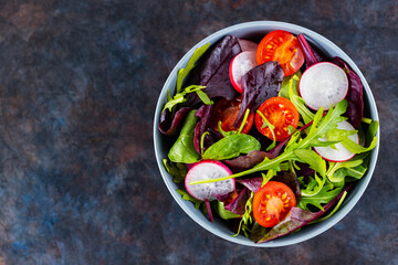 Salad with cherry tomatoes, radish and mix salad. Healthy salad, leaves mix salad. Paleo diet concept. Copy space. Top view