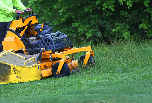 Manual Worker Mowing The Lawn