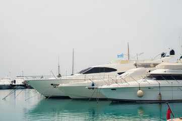 Fototapeta premium Boats parking in harbor. Sea yacht club. Aegean sea. Athens, Greece. White cloudy sky.