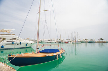 Obraz na płótnie Canvas Yacht parking in harbor. White sailing yachts at the pier. Sea yacht club. Aegean sea. Athens, Greece. Blue sky.